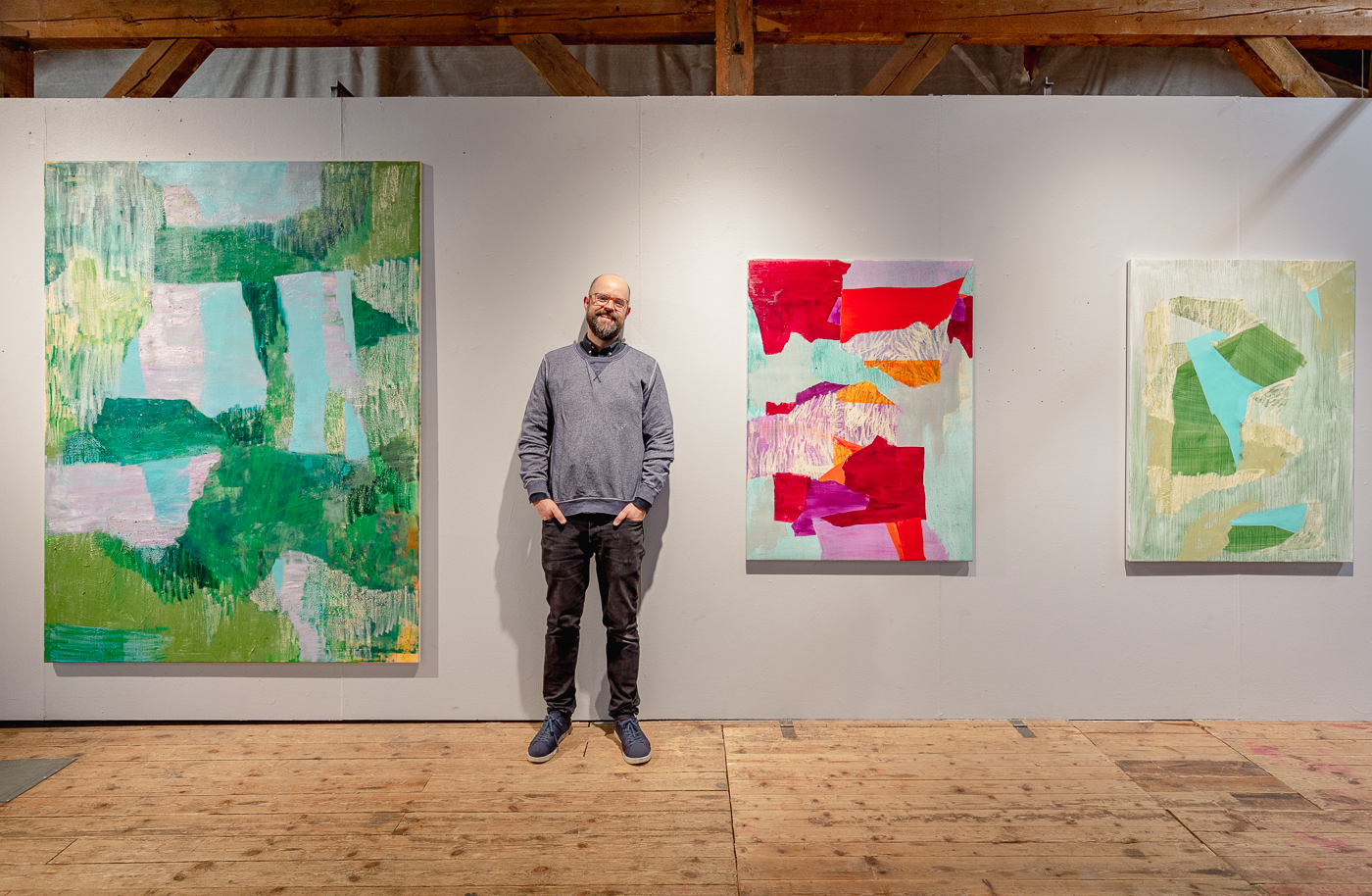 Photo of the artist and three paintings from NP33 exhibition